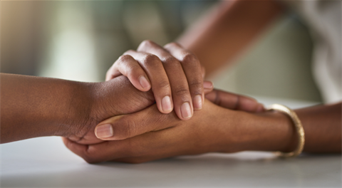 close up of two people holding hands supportively