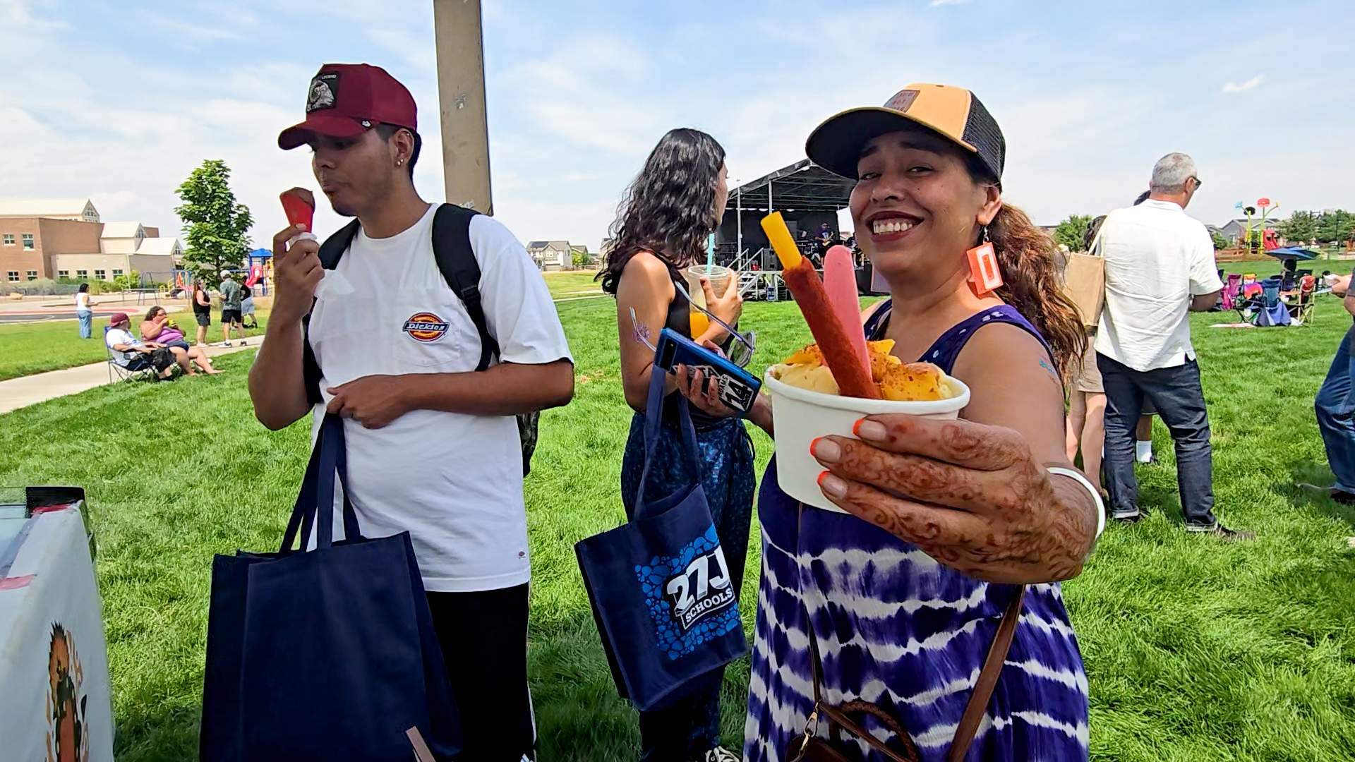 Woman holding food up to a camera, smiling. 