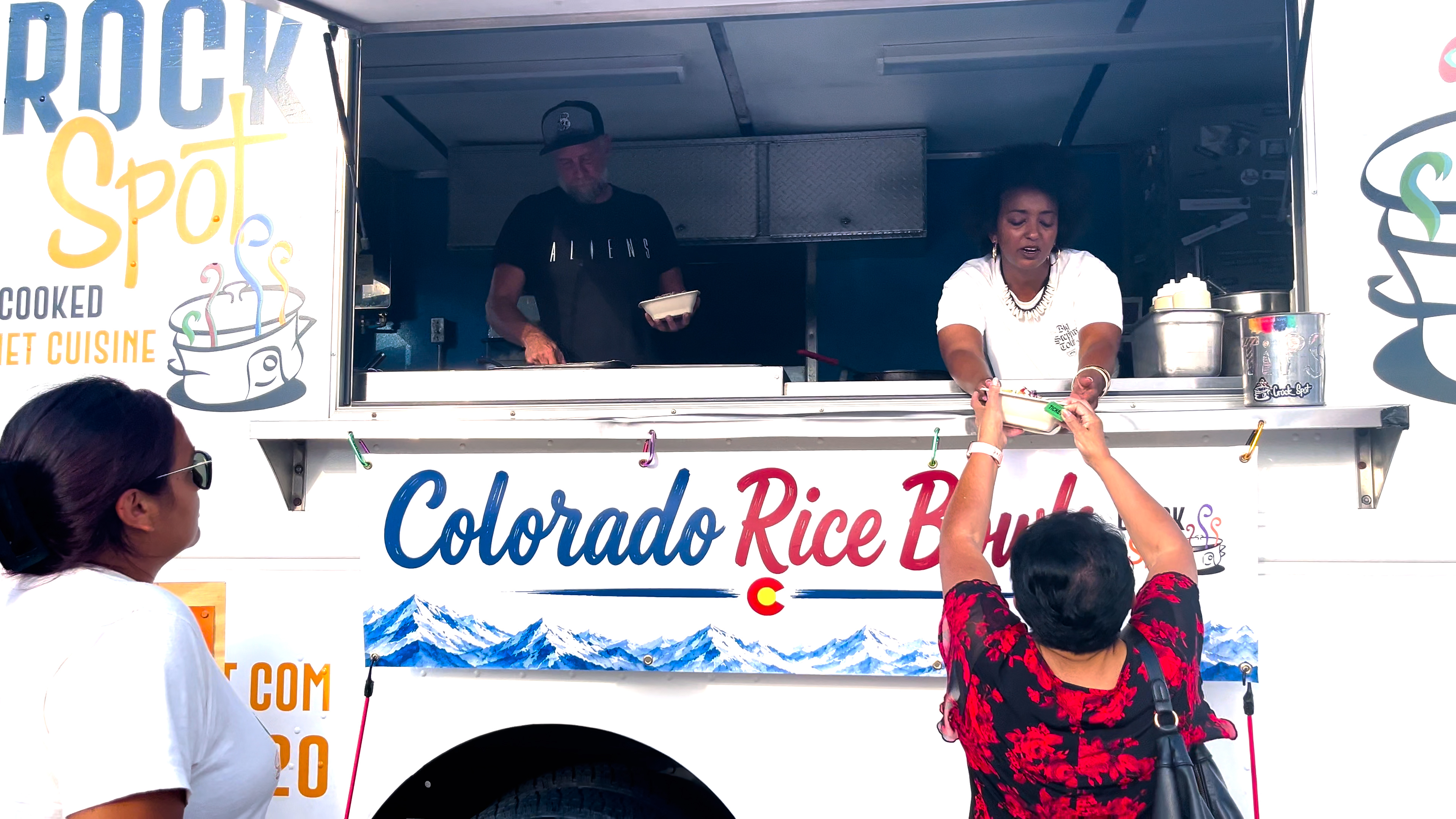Woman gets food from a food truck. 