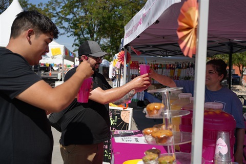 Person buys something from a booth. 