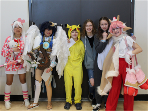 People posing for a picture in character costumes for Minicon. 