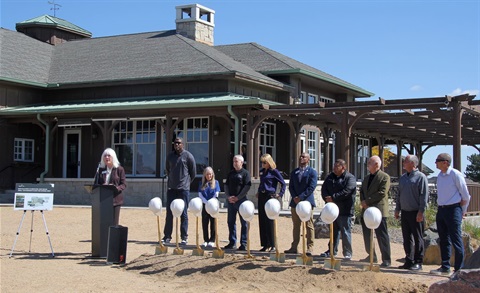 People standing in front of building with hard hats. 