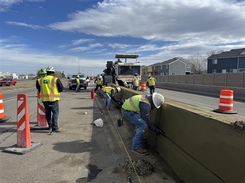 Workers working on a median on a road. 