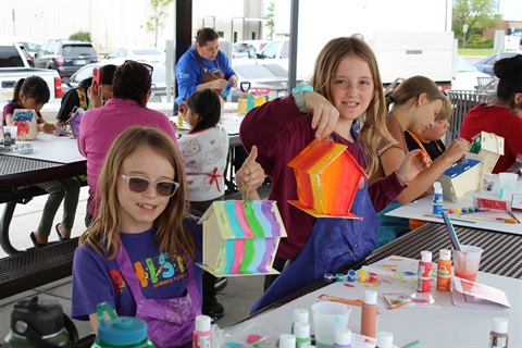 Children in park making bird house craft