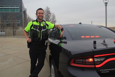 Curt Holland stands next to a police car. 
