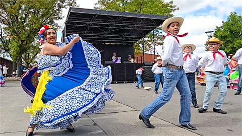 Hispanic dancers in front of stage. 