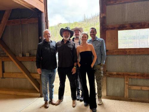 5 band members standing in a barn