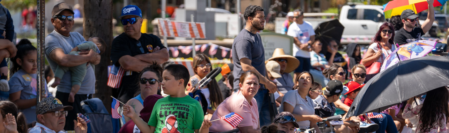 People watching a parade from the sidewalk. 