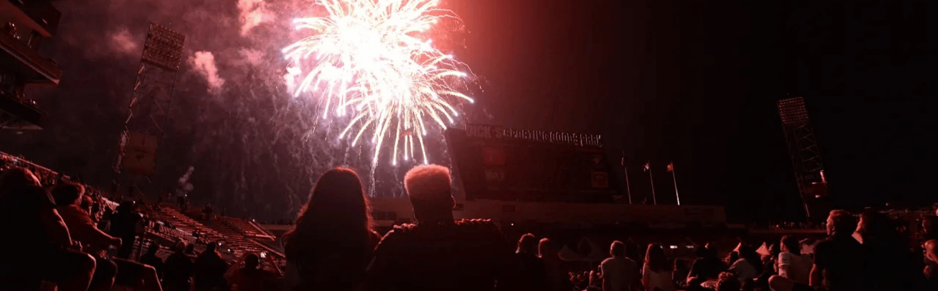 July 4 fireworks explode over DICK's Sporting Goods Park as people watch on the field